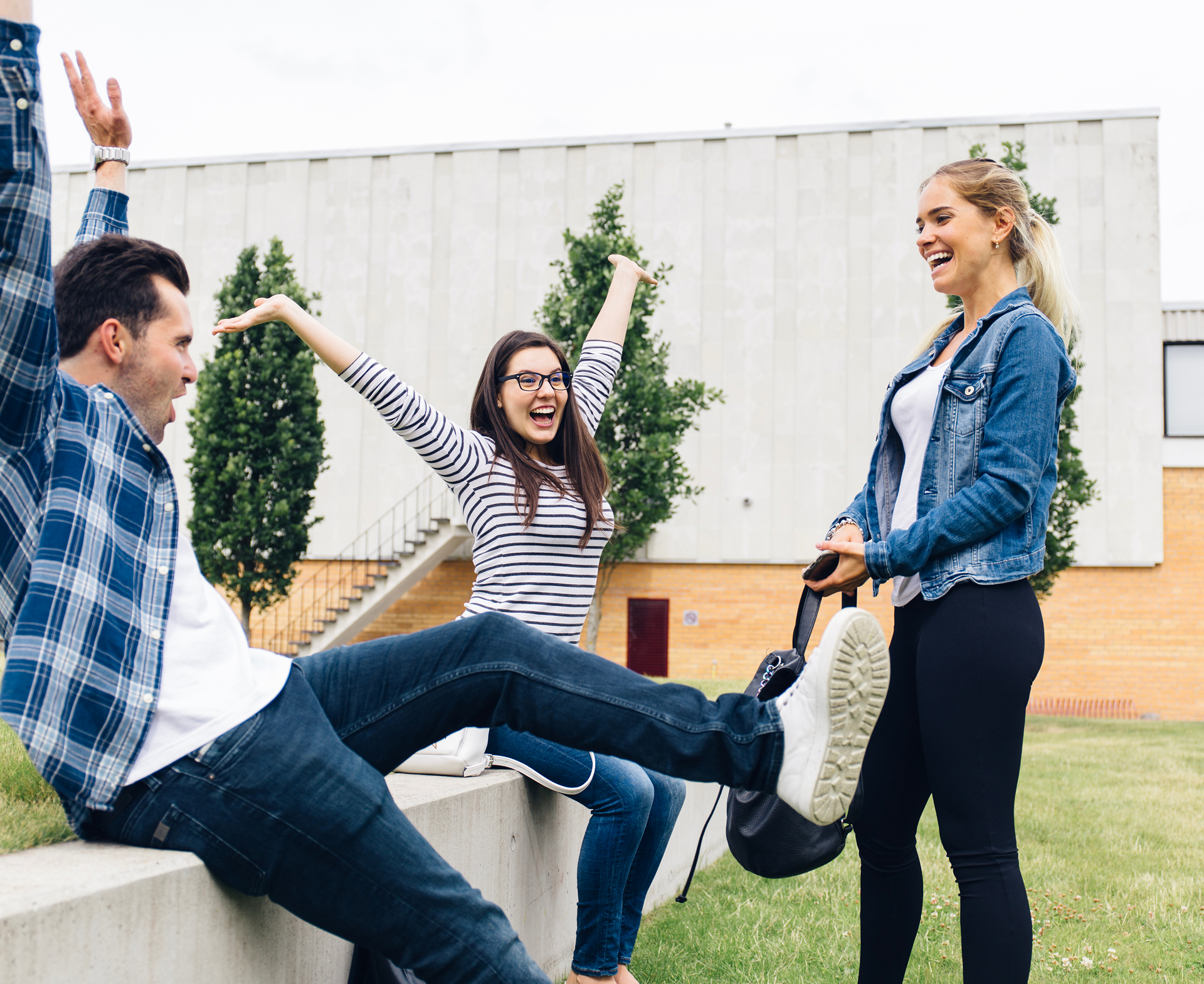 Three friends laughing together outdoors
